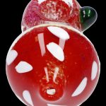 Red glass mushroom-shaped cannabis pipe with white spots.