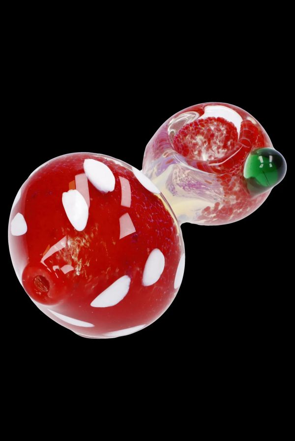 Red and white spotted glass mushroom dab rig with green accents.