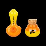 Orange glass pipe and storage container with cork lid, branded “Pulsar.”