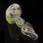 A close-up, angled view of the Green Slyme and Bubble Gum Inside-Out Pipe with Black Marbles, highlighting its translucent glass swirls.