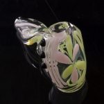 A close-up, angled view of the Green Slyme and Bubble Gum Inside-Out Pipe with Black Marbles, featuring colorful glass swirls.