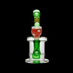 Green and red glass dab rig with percolator, isolated on a black background.
