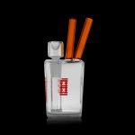 Clear glass bubbler with orange accents and red branding, isolated on a black background.