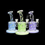 A side view of the Honeycomb Drip Dab Rig, showcasing its clear glass construction with vibrant blue and green accents.