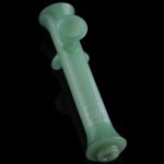 Green glass cannabis pipe isolated on a black background.
