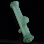 Frosted green glass pipe against a black background.