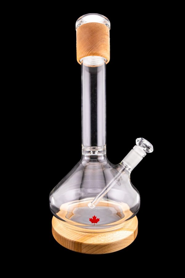 Glass water pipe with a wooden base and a Canadian maple leaf design, isolated on a black background.