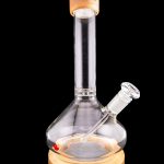 Glass water pipe (bong) with a wooden base and mouthpiece, isolated on a black background.