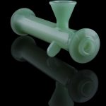 Frosted green glass bubbler with a reflection on a black background.