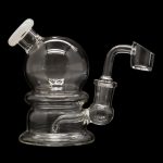 Clear glass dab rig with a quartz banger, isolated on a black background.