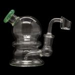 Clear glass dab rig with green accent and quartz banger.
