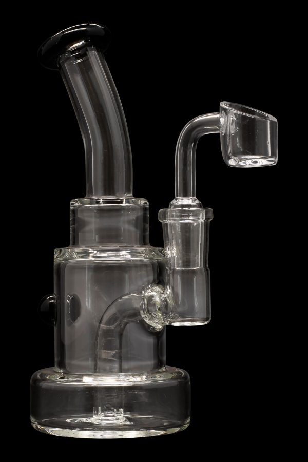 Clear glass dab rig with a quartz banger, isolated on a black background.