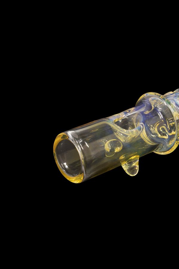 Glass cannabis oil burner pipe with colorful swirls against a black background.