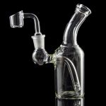 Clear glass dab rig with quartz banger, isolated on black.