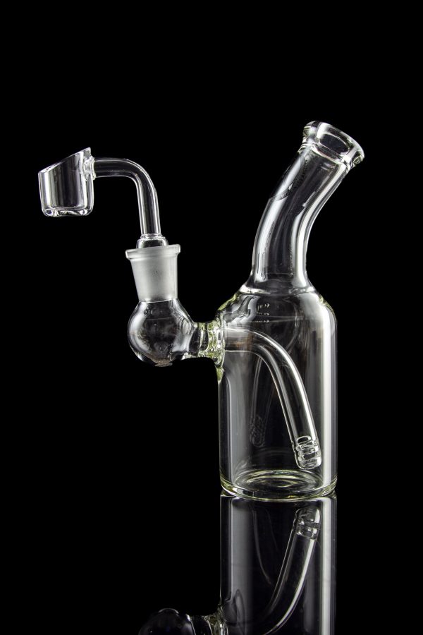 Clear glass dab rig with quartz banger, isolated on black.