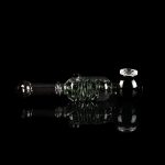 Clear glass rig with intricate bubbler design, reflecting on a dark surface.