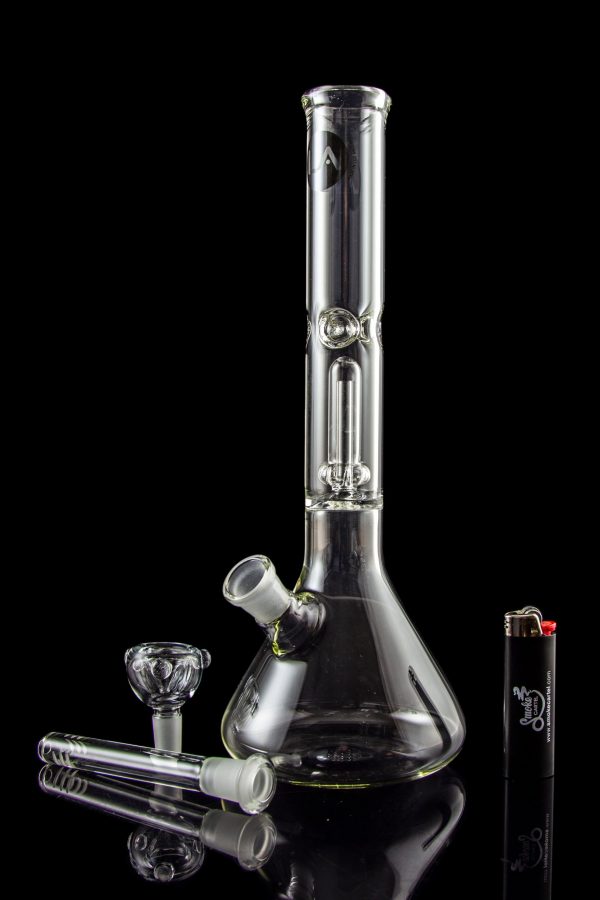 Glass bong with accessories and lighter on a reflective surface.