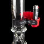 A glass water pipe (bong) with intricate bubble detailing, featuring a red accent and branded with “Snowtree”. A small black lighter is clipped to the neck of the pipe.