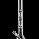Clear glass bong with intricate bubbler and reflective surface against a black background.