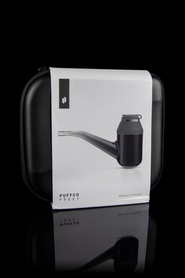 Puffco Proxy vaporizer in a closed white carrying case, reflecting on a glossy black surface.