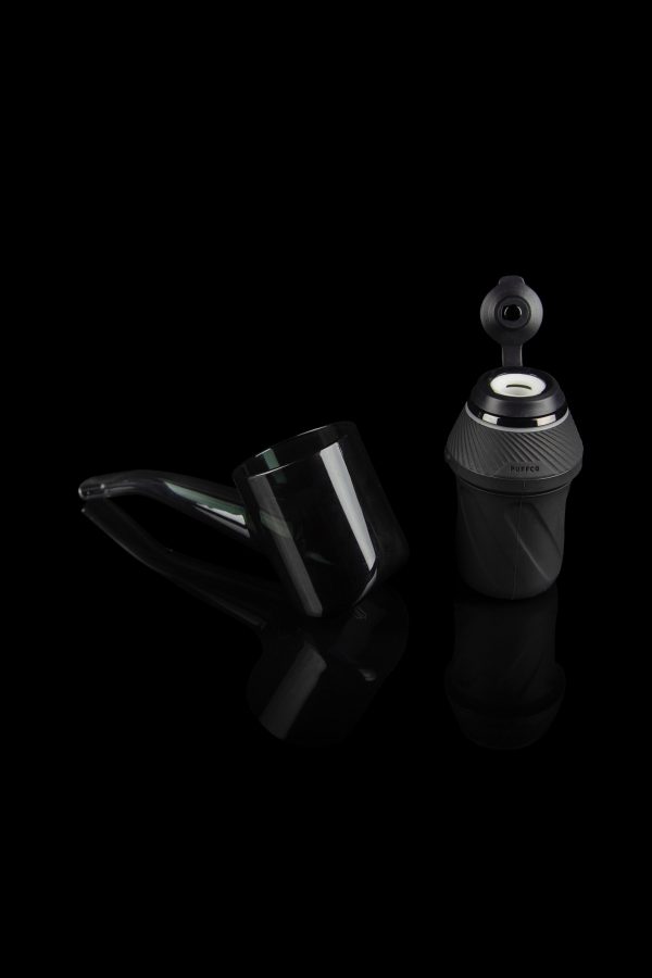 Puffco Peak Pro portable dab rig with accessories on a reflective surface.