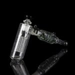 Clear glass water pipe (rig) with intricate percolators against a black background.