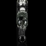 Clear glass bubbler water pipe with skull-shaped chambers, isolated on black.