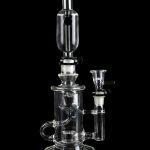 Clear glass water pipe (rig) with intricate branching percolators, against a black background.