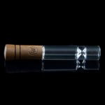 Wooden-tipped glass chillum with visible flower inside, against a black background.