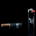 Glass oil burner pipe and lighter on a black background.