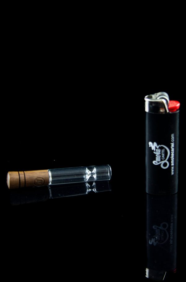 Glass oil burner pipe and lighter on a black background.