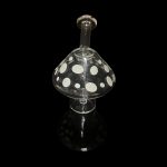 Glass mushroom-shaped oil rig with polka dots, isolated on black.