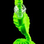 Glowing green glass seahorse-shaped dab rig with a glass orb.