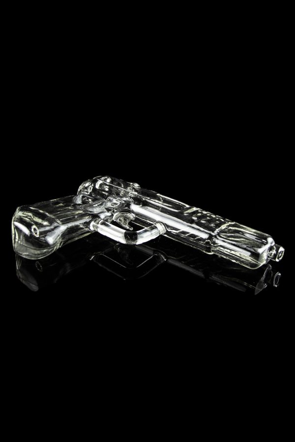 Glass pistol-shaped cannabis pipe on a reflective black surface.