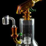 Glass water pipe (rig) with orange accents and bubbler, isolated on black.