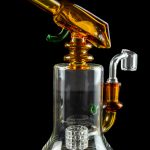 A colorful glass dab rig with a perc filter and quartz banger, isolated on a black background.