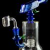 Blue glass dab rig with quartz banger and intricate percolator, isolated on black.