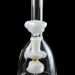Glass bubbler water pipe with white percolator chambers against a black background.
