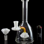 Clear glass water pipe (bong) with colorful attachments, displayed on a reflective surface against a black background.