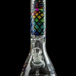 A colorful glass water pipe (bong) with a cannabis leaf design, isolated on a black background.