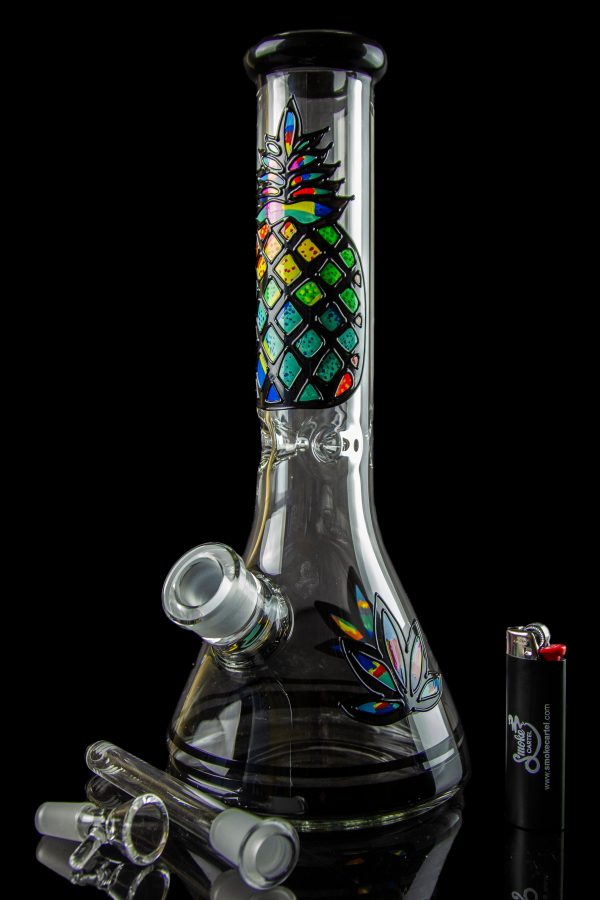 A colorful glass bong with a patterned design, accompanied by glass smoking accessories on a dark background.