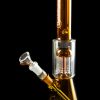 Amber glass water pipe (bong) with a clear glass bowl against a black background.