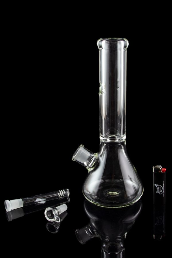 Glass bong and accessories on a reflective surface.