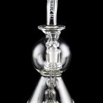 Clear glass water pipe (rig) with intricate perc filtration, branded "Pulsar" on the mouthpiece.