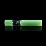 Glowing green cannabis oil vape pen with a metallic center section, displayed on a reflective black surface.