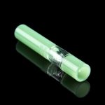 Green glass cannabis bubbler with visible water filtration chamber, reflected on a black surface.