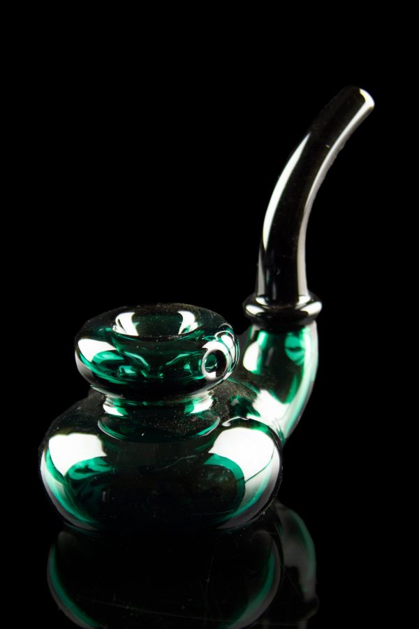 Emerald green glass bubbler with intricate swirls, reflecting on a dark surface.