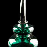 Emerald green glass oil rig with a bubbler design, isolated on black.