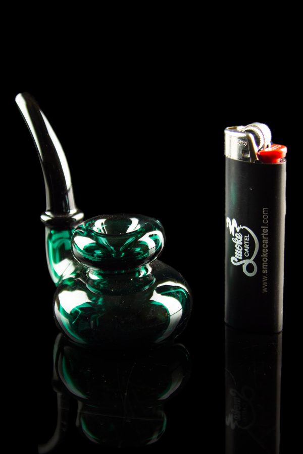 Green glass bubbler pipe and lighter against a black reflective surface.