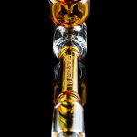 A vibrant glass pipe with orange and yellow accents, featuring the brand name “Pulse” etched along its clear body.